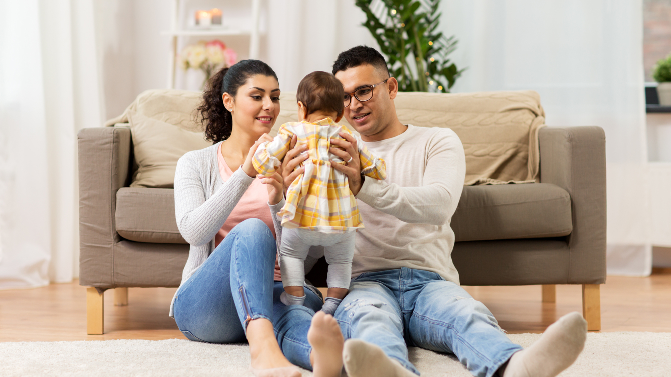 Jong stel met kind wat op de schoot staat van de ouders