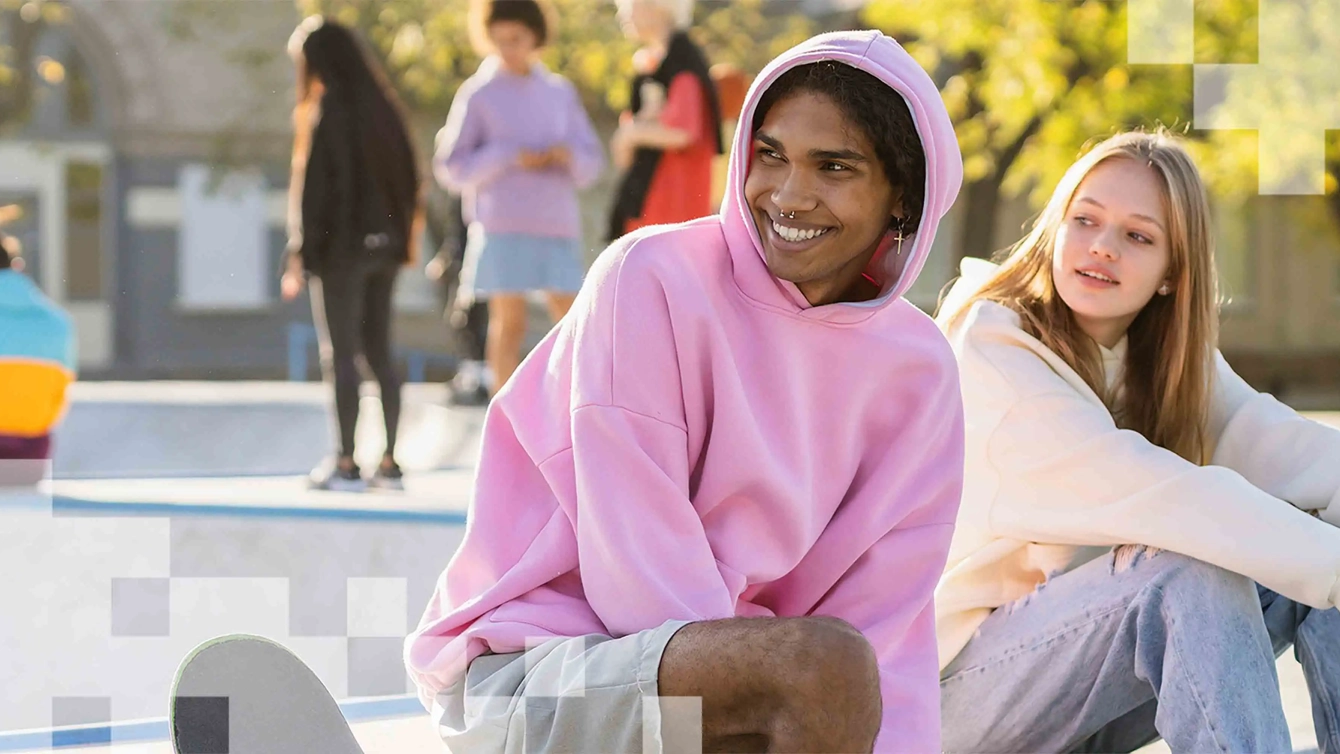 2 jongeren zitten op een rand en kijken opzij